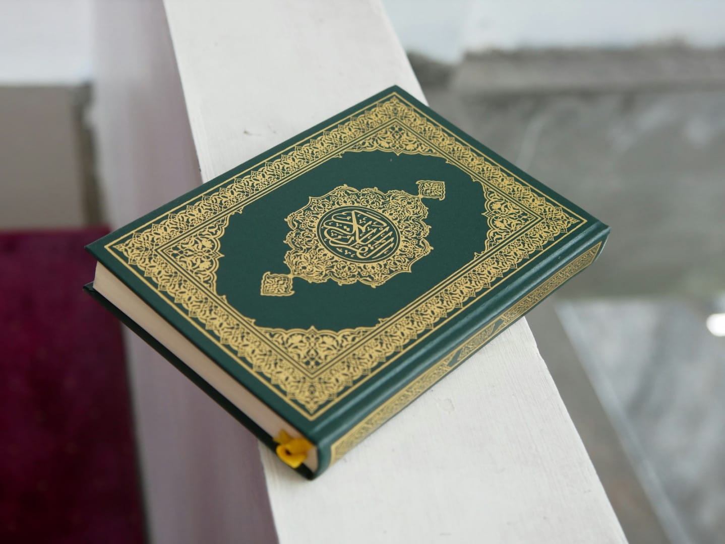 a green and gold book sitting on top of a white table
