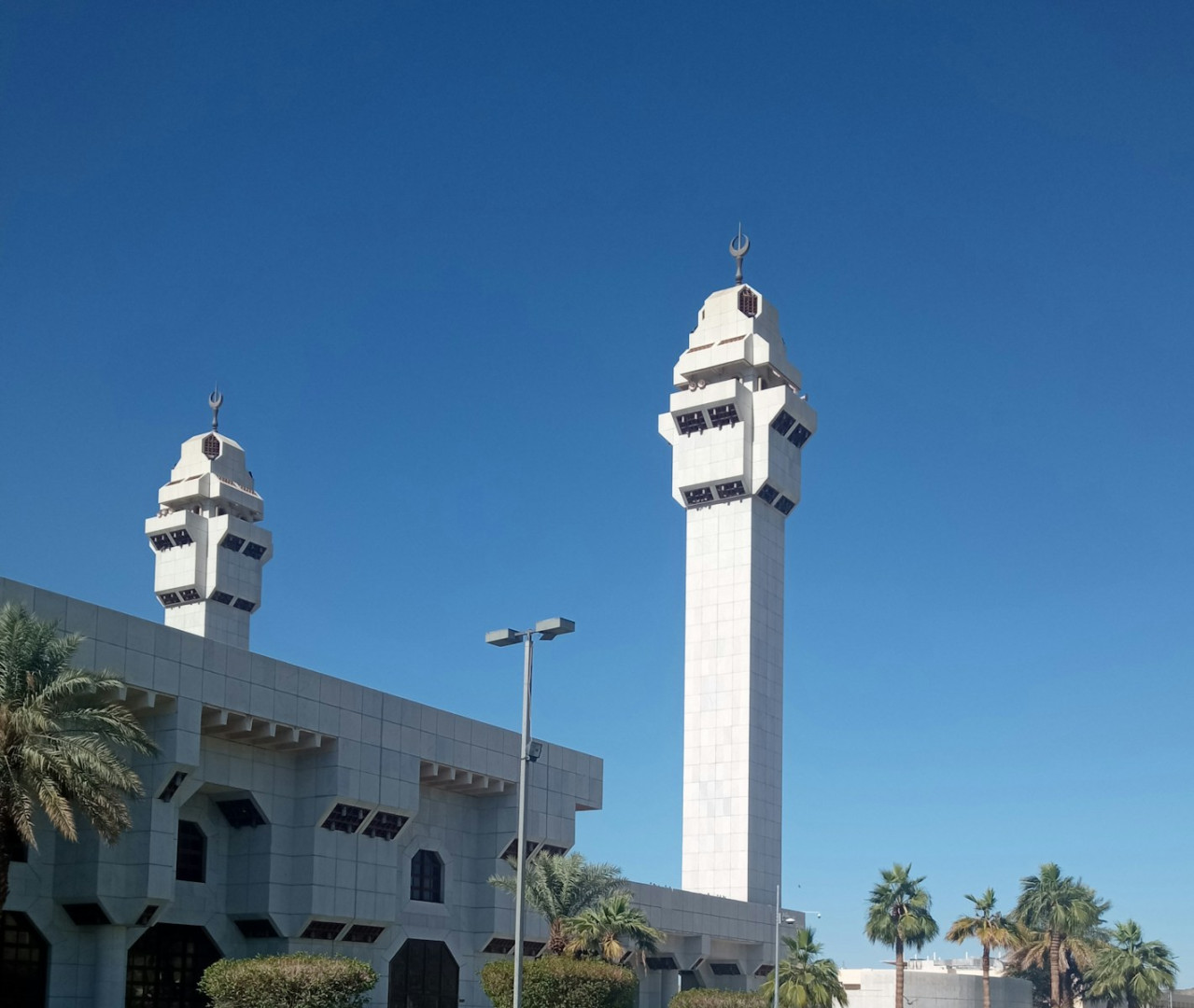 a tall white clock tower sitting next to a tall white building